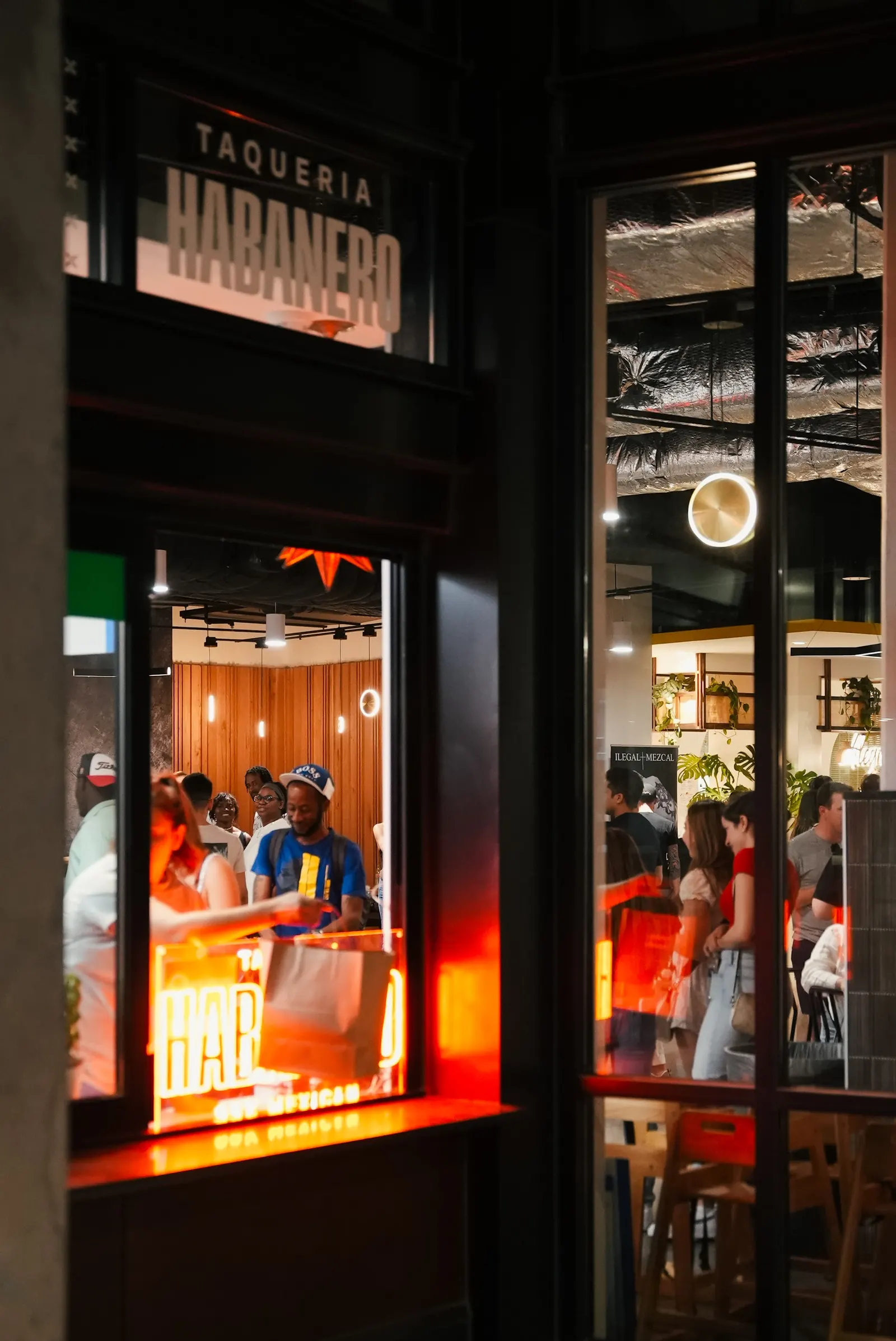 Evening crowd inside Bryant Street Market in Washington seen through the glass front