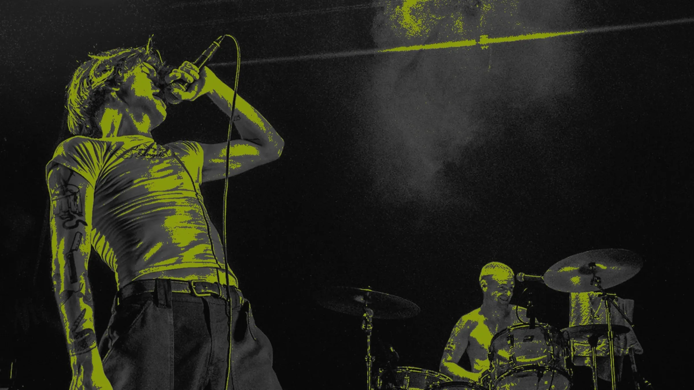 Singer performing live at The Dome with dramatic yellow stage lighting and drummer in the background