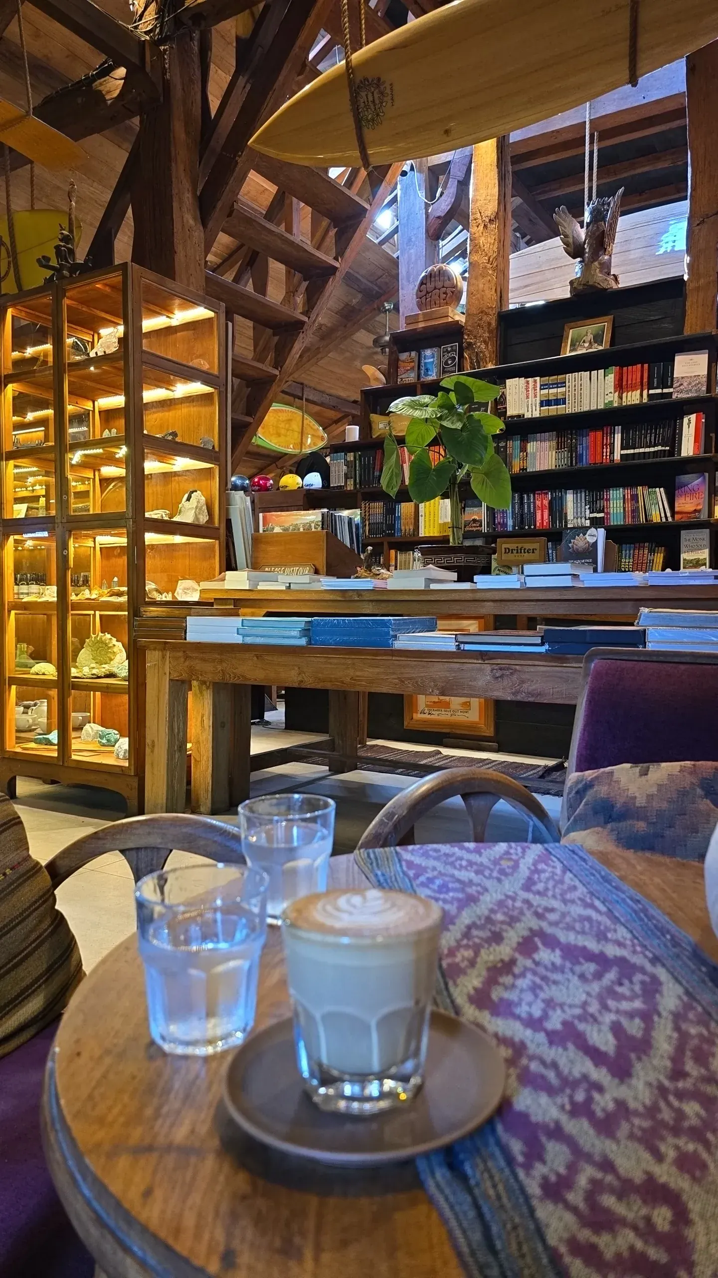 Cozy interior with bookshelves, surfboard ceiling, and wood architecture at Rolling Fork in Bali