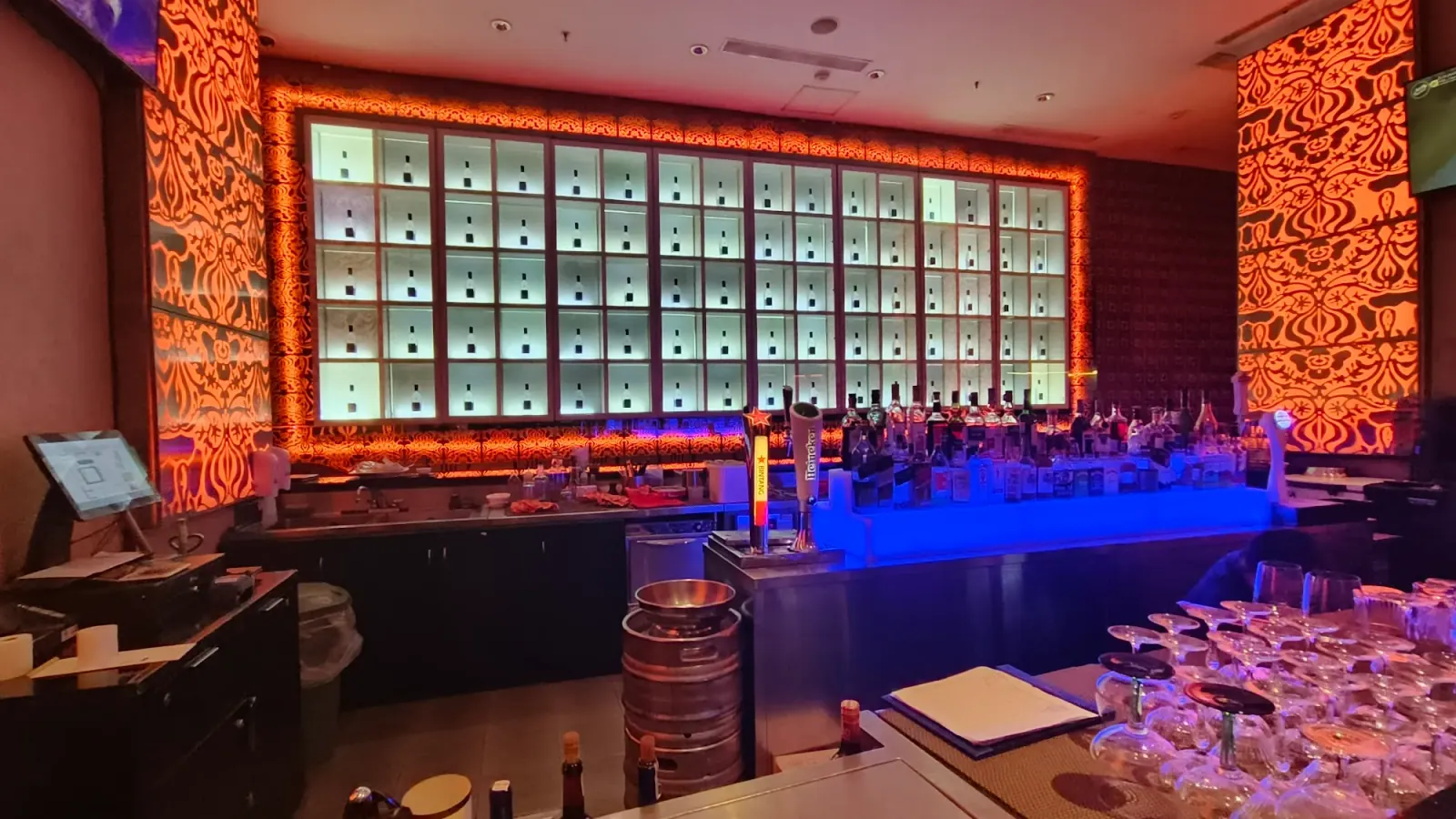 Blu Martini bar interior with orange backlit bottle display and blue counter
