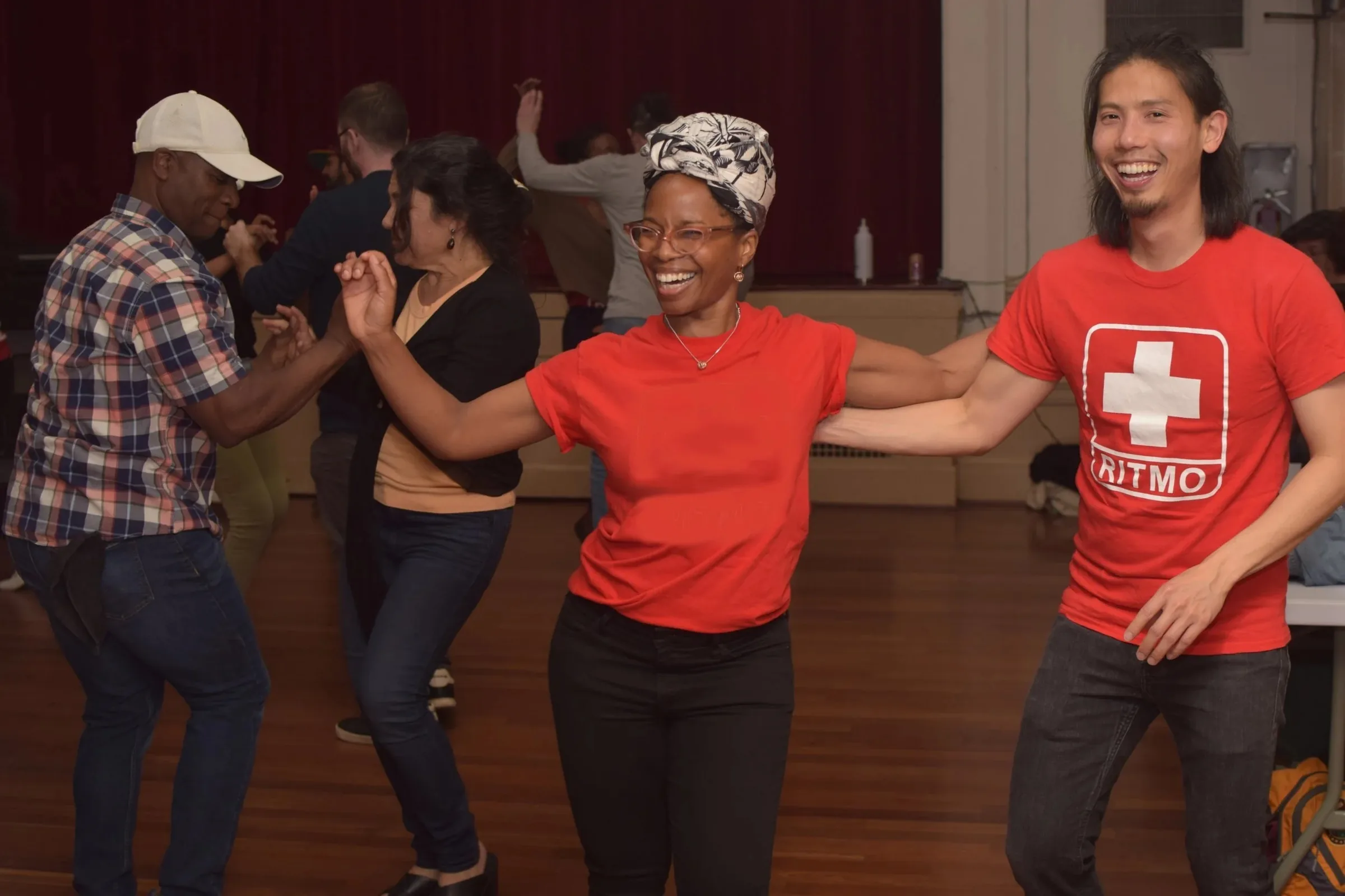 Dancers laughing mid-turn during a salsa social at Lake Merritt Dance, Oakland