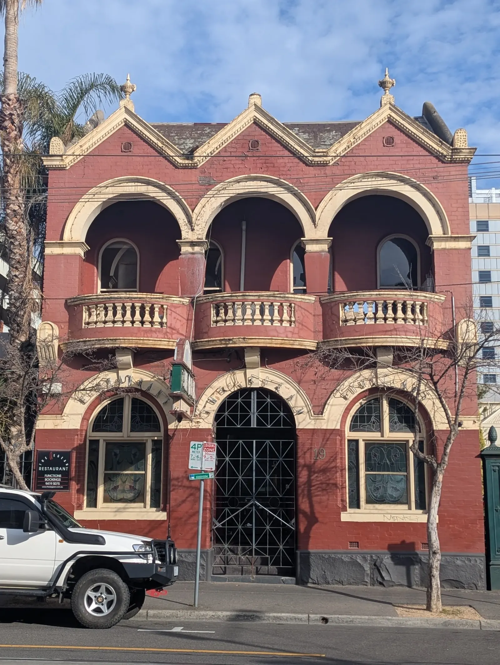Heritage red-brick facade and signage of The Aegean Restaurant in Melbourne